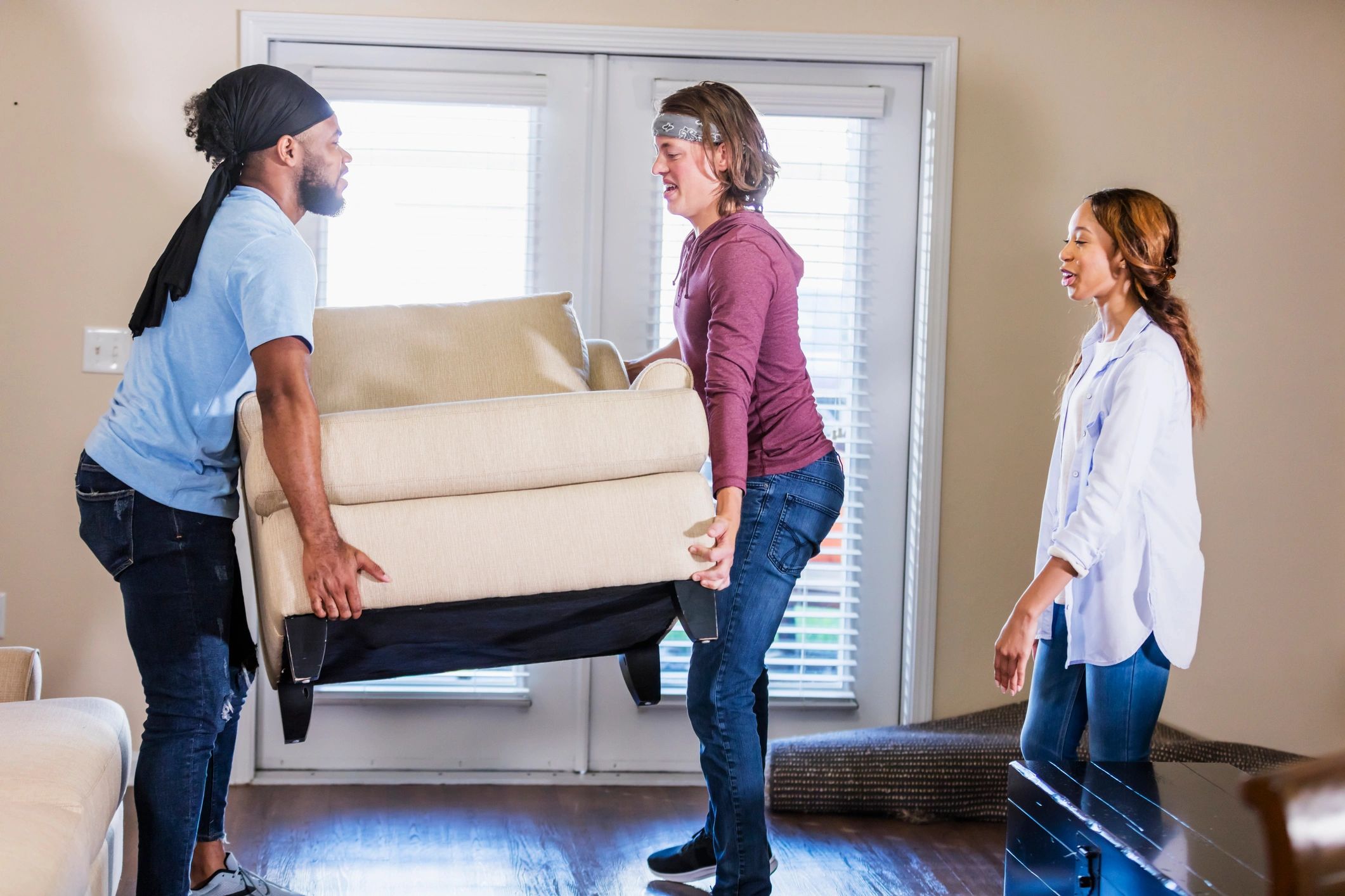 Professional movers carrying an armchair in a living room