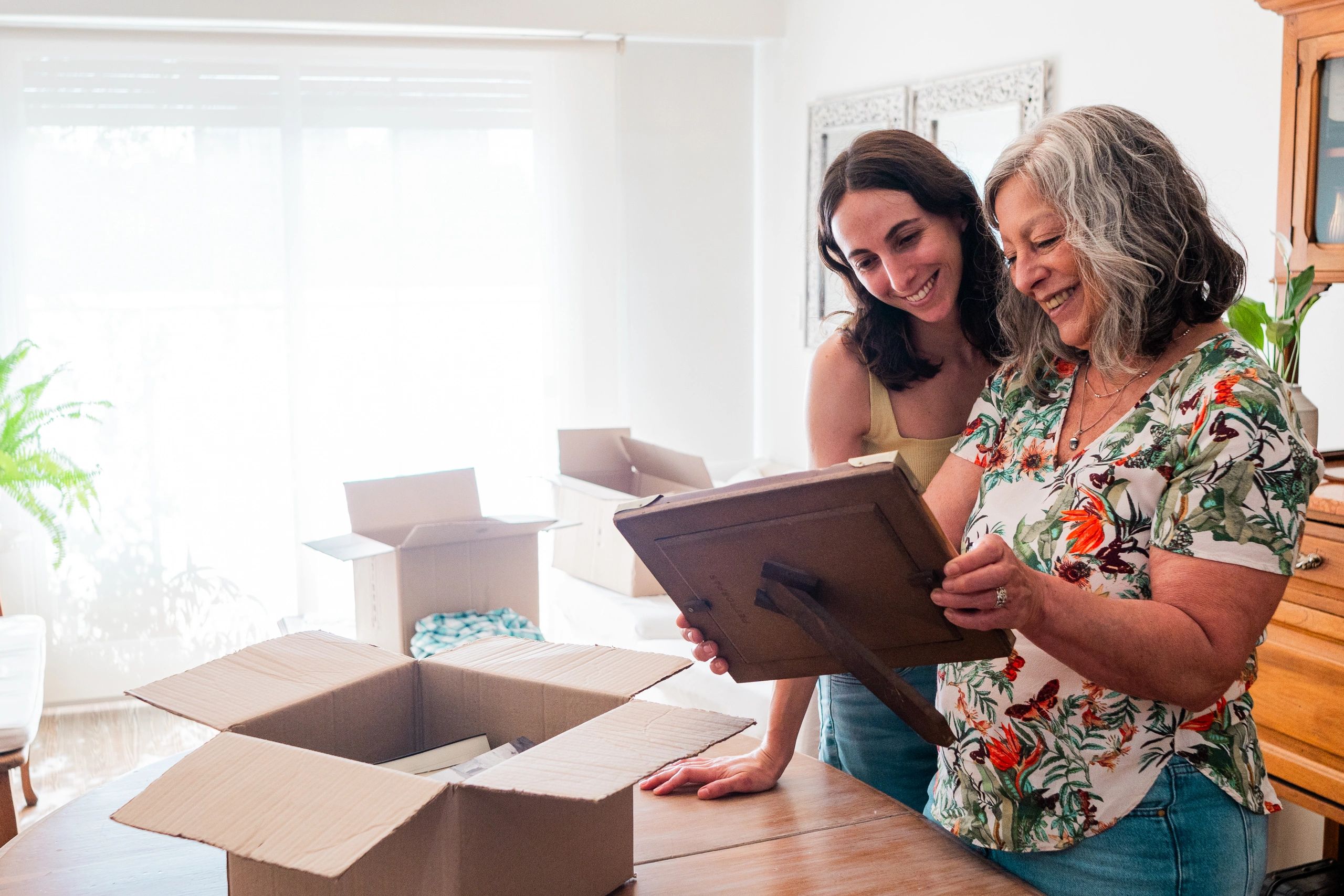 Customer holding a framed photo while unpacking during a house move